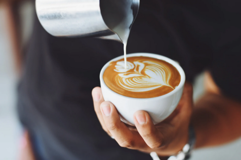 Person finishing pouring latte art