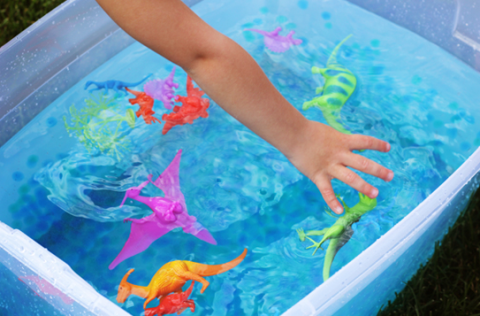 child playing in bin of water