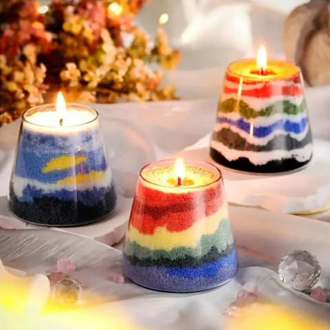 three layered sand wax candles on a table
