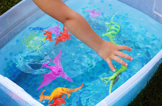 child playing in bin of water